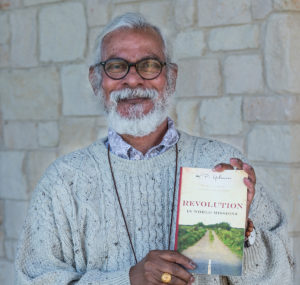 Dr. KP Yohannan holding his book